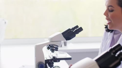 Científicos con microscopios trabajando en laboratorio