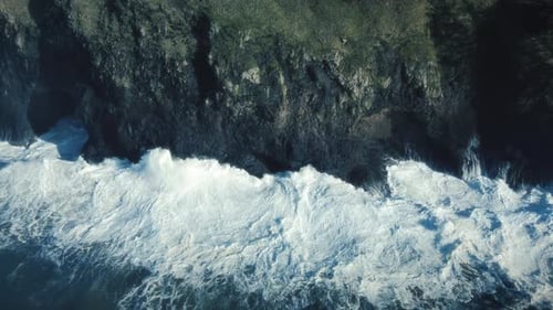 Artistic Blue Coastal Background Aerial Of Slow Motion Waves Crashing Rock Cliff