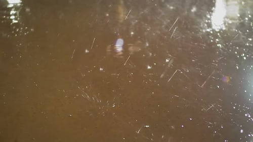 Regentropfen fallen mit Spritzern in Zeitlupe auf den Boden, Schönheit der Natur