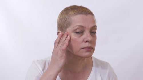 Retrato de mujer madura mirando a la cámara como un espejo y preocuparse por su cara con arrugas