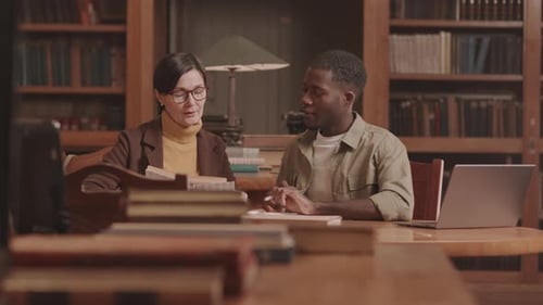 Professor and Student Talking in Library