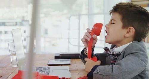 Upset Boy Shouting into a Red Rotary Phone