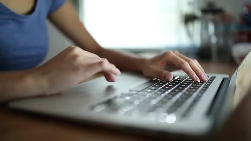 Hands Typing on Laptop Keyboard Close-Up