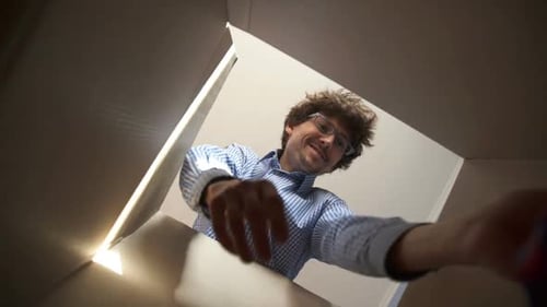 Man Unpacking Clothes from a Cardboard Box