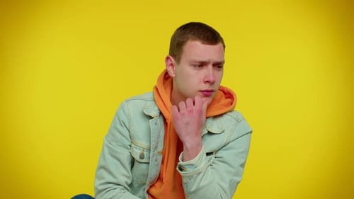 Young Man Thinking Deeply on Yellow Background