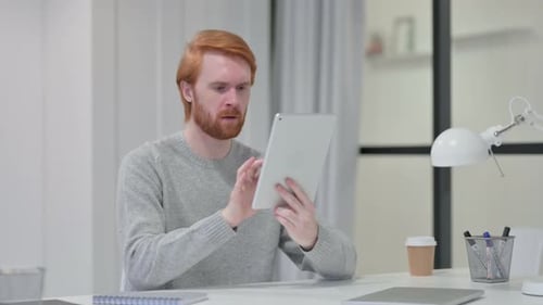 Man Looks at Tablet with a Confused Expression