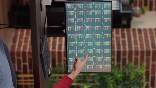 Person Analyzing Stock Market Data on Outdoor Monitor