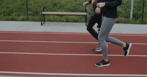 Side View of Disabled Man and Sports Woman Taking Position on Marks and Start Running