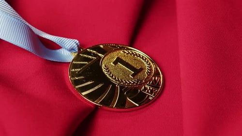 Gold Medal With Light Blue Ribbon on Red