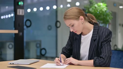 Focused Businesswoman Doing Paperwork in Office