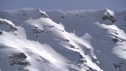 Snow Eaves and Sastrugi Accumulated on Mountain Ridge