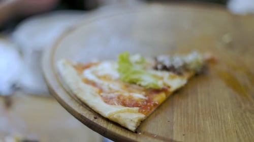 Close-Up of Delicious Pizza Slice on Wooden Platter