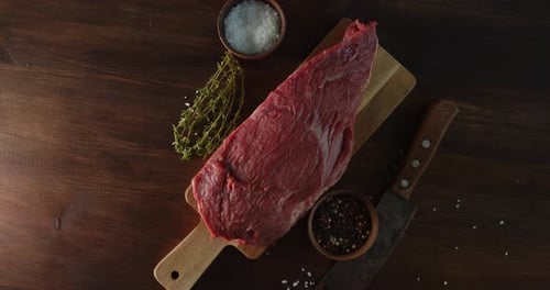 Raw Steak on Cutting Board with Fresh Herbs