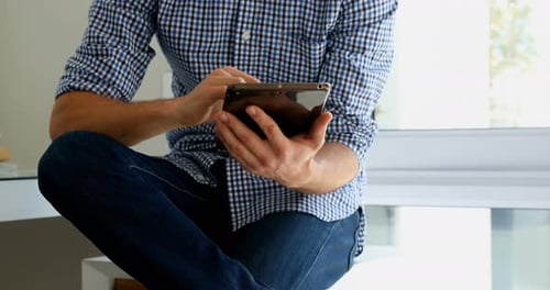 Man Using Tablet While Thinking in Home