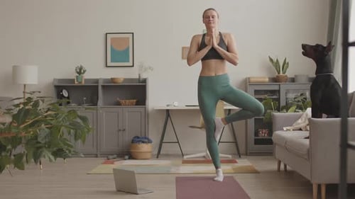 Woman Doing Yoga With Her Dog At Home