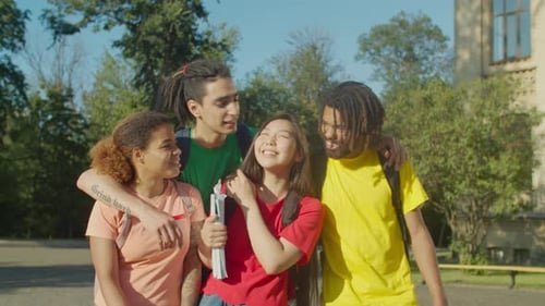 Four Cheerful Students Walk Together on Campus