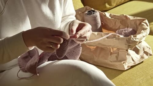 Woman Knitting Thread from the Package on a Sunny Day