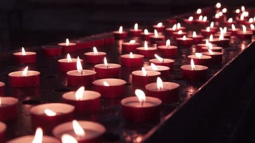 Glowing Votive Candles Burning in the Dark