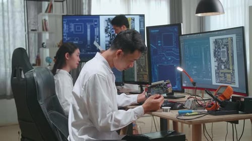 Engineers Work on Circuit Boards in Workplace