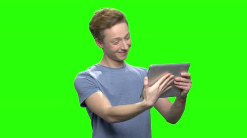 Young Adult Using Tablet on Green Screen