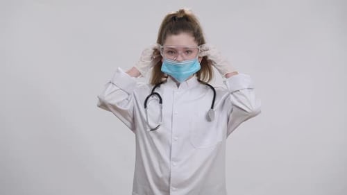 Girl in Lab Coat Puts on Protective Mask