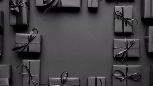 Arranged Gifts Boxes Wrapped in Black Paper with Black Ribbon on Black Background. Christmas Concept