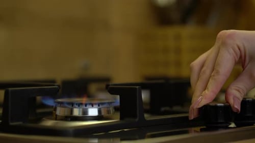 Close Up Woman Hands in the Kitchen Uses a Gas Stove and Puts the Kettle