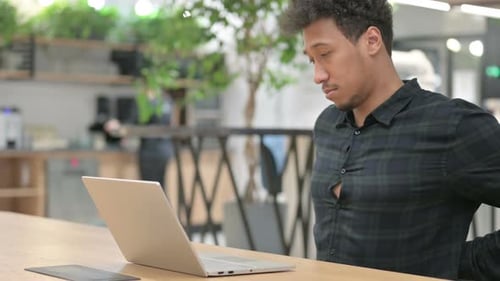 Young Adult Typing on Laptop at Office Desk