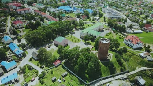 Flight Over A Provincial Town. An Ancient Tower Among The Multi Colored Roofs Of Houses
