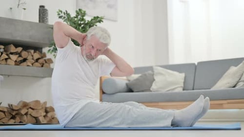 Senior Man Exercising at Home on Yoga Mat