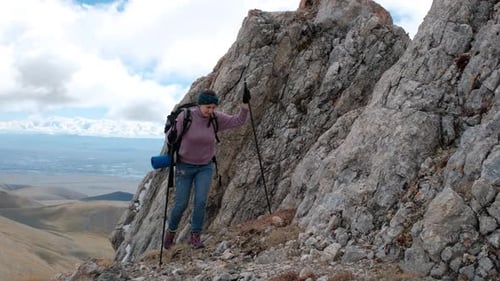 Woman Hiker Climbing Rock on Mountain Peak Cliff