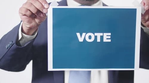 Sign Encouraging Voting by a Man in Blazer