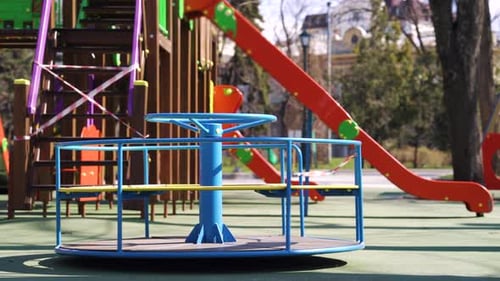Abandoned carousel and slides with restriction tape on empty playground