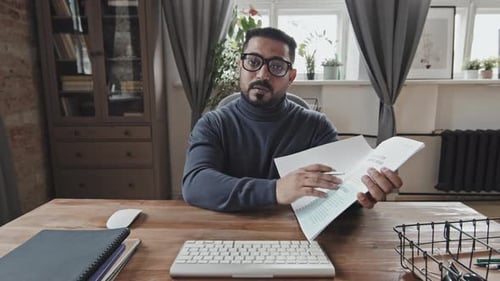 Professional Man Explaining Documents in Home Office