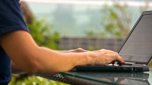 Homem navega com tipos de Internet em laptop contra árvores