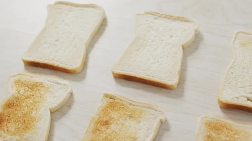 Video von unterschiedlich gebackenen Toasts, die von oben auf Holzarbeitsplatte sehen