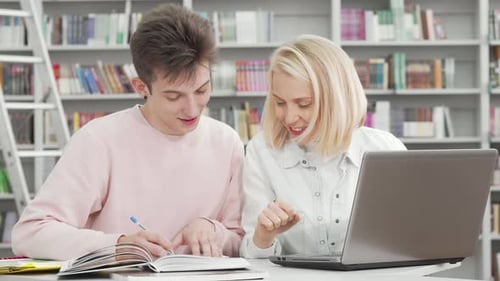 Two College Students Working on a Project Together at the Library