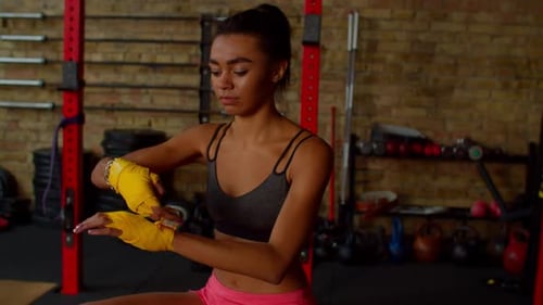 Woman Wraps Hands for Boxing at the Gym
