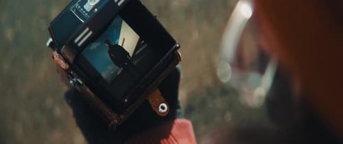 Close up an checking video on preview screen of his vintage camera