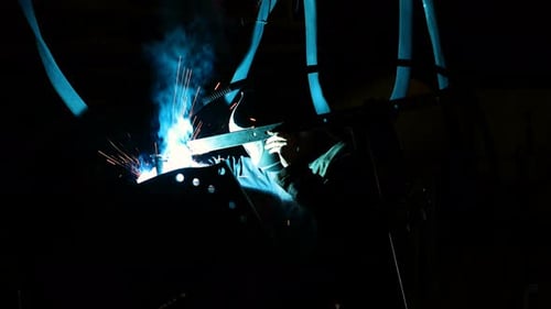 Employee Of Metal Plant Welding In Dark