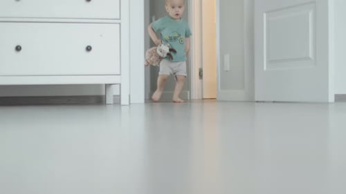 First Steps Barefoot Legs Toddler Child on Floor Indoors Baby Running to Camera