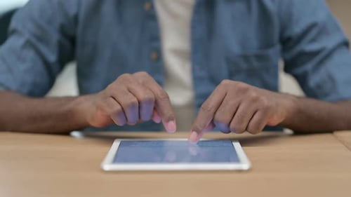 Close Up of Hands of African Man Typing on Tablet