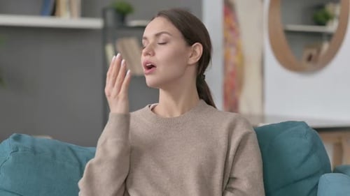 Porträt einer Frau, die auf dem Sofa gähnt