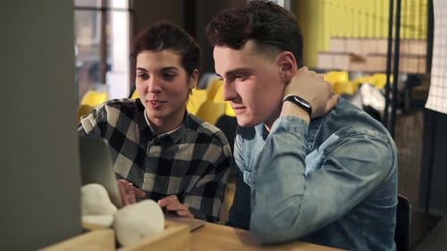 Young Adults Working on Laptop Together in Office