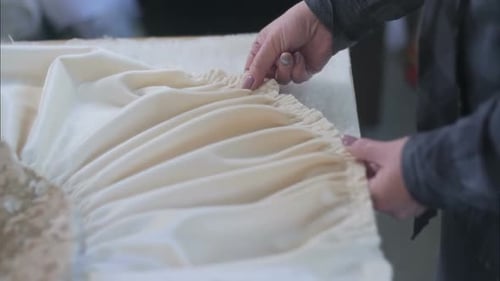 Hände des Designers bei der Arbeit mit Stoff