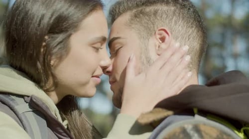 Romantic Couple Sharing a Kiss in Forest