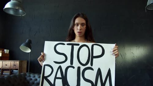 Woman Holding Stop Racism Sign Indoors