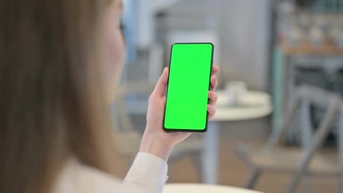 Woman Browsing Smartphone with Green Chroma Key Screen Rear View