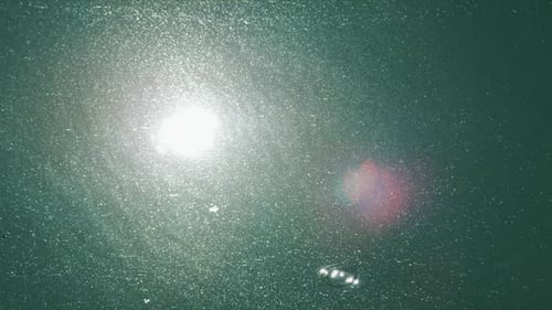 Die Sonne reflektiert direkt auf klarem Wasser mit einer Regenbogenkugel an der Seite