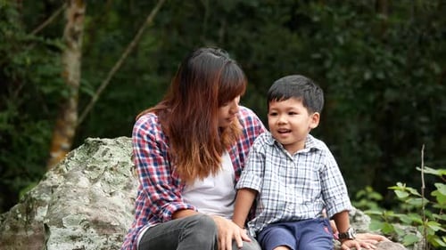 Mutter und Sohn sitzen entspannt in der Natur.